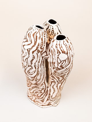photograph of earthen ceramic sculpture, hand painted with patterns, side view, thumbnail
