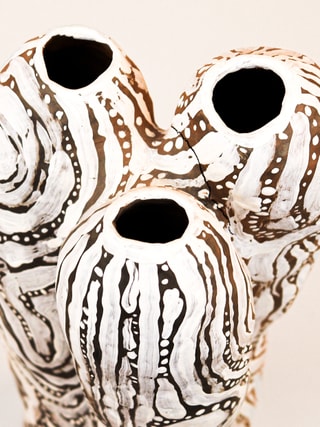 photograph of earthen ceramic sculpture, hand painted with patterns, close up aerial view, thumbnail