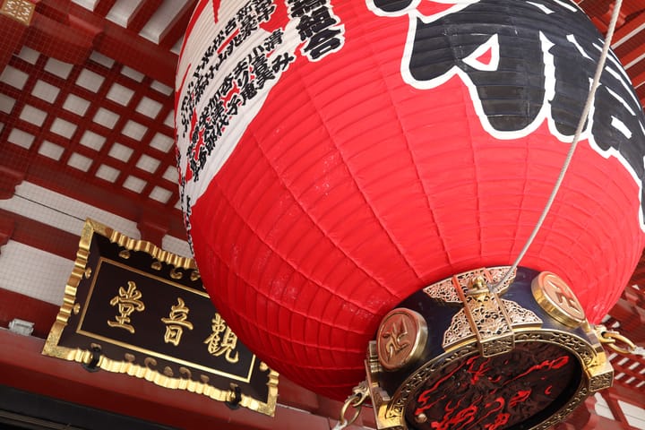 Big red lantern close up, japanese writing on across it, as well as gold ornamentation, thumbnail